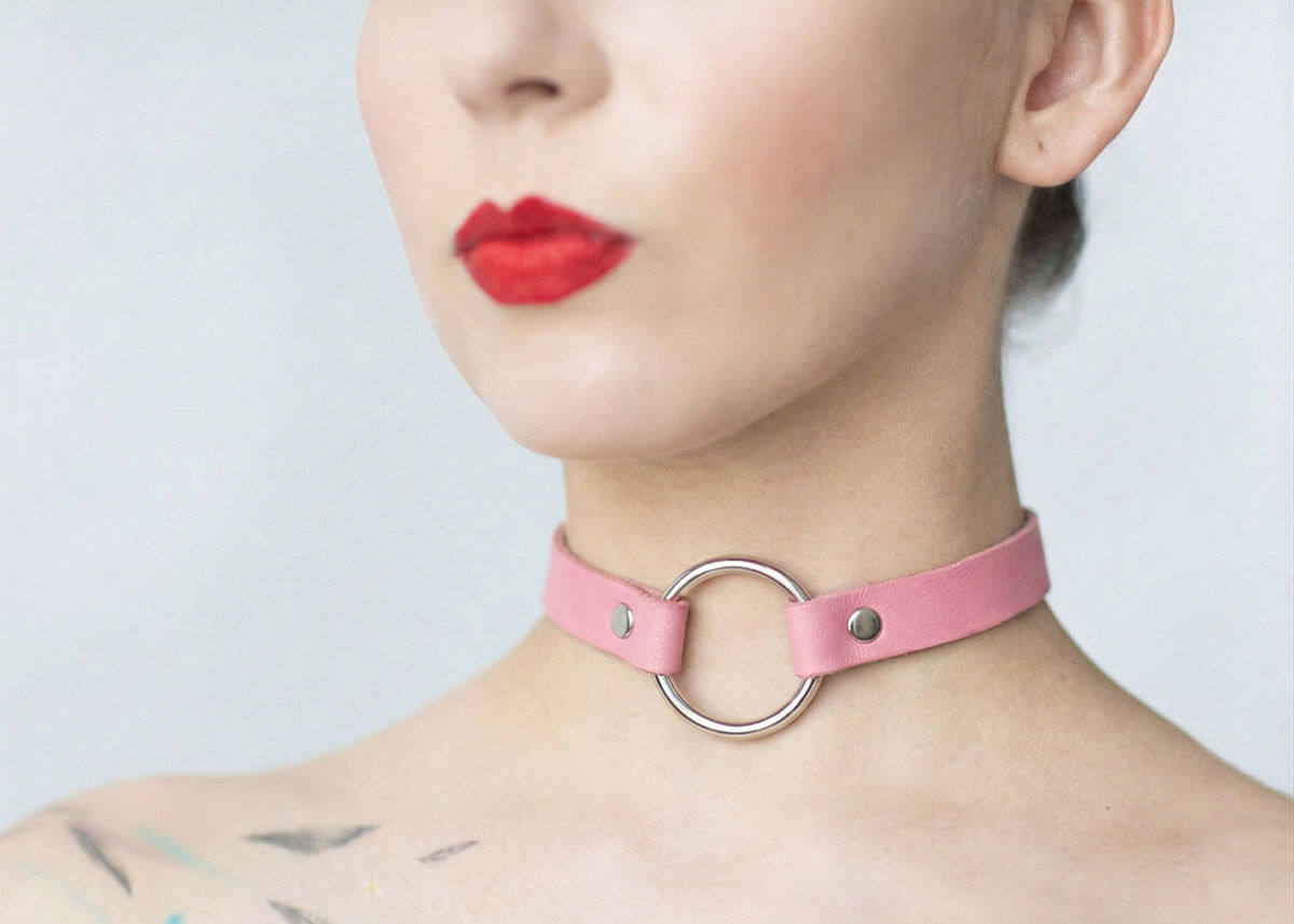 Kožený Choker C001 v ružovej farbe so strieborným krúžkom je spojením nevinnosti a provokácie, ktorá okamžite pritiahne pozornosť. Sladký na pohľad, no odvážny vo vnútri.
