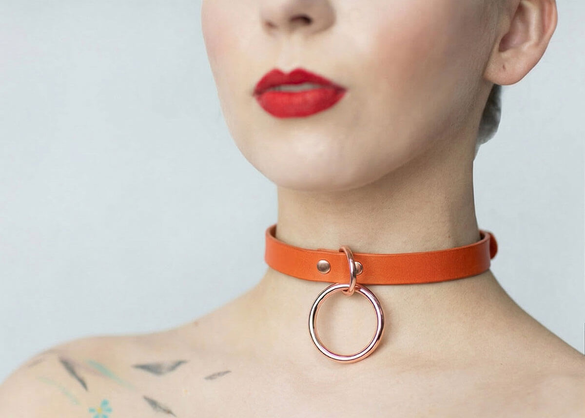 Kožený Choker C002 v oranžovej farbe s visiacim strieborným krúžkom zaujme tónom žhavej predohry. Svieži doplnok dodá každému outfitu iskru.