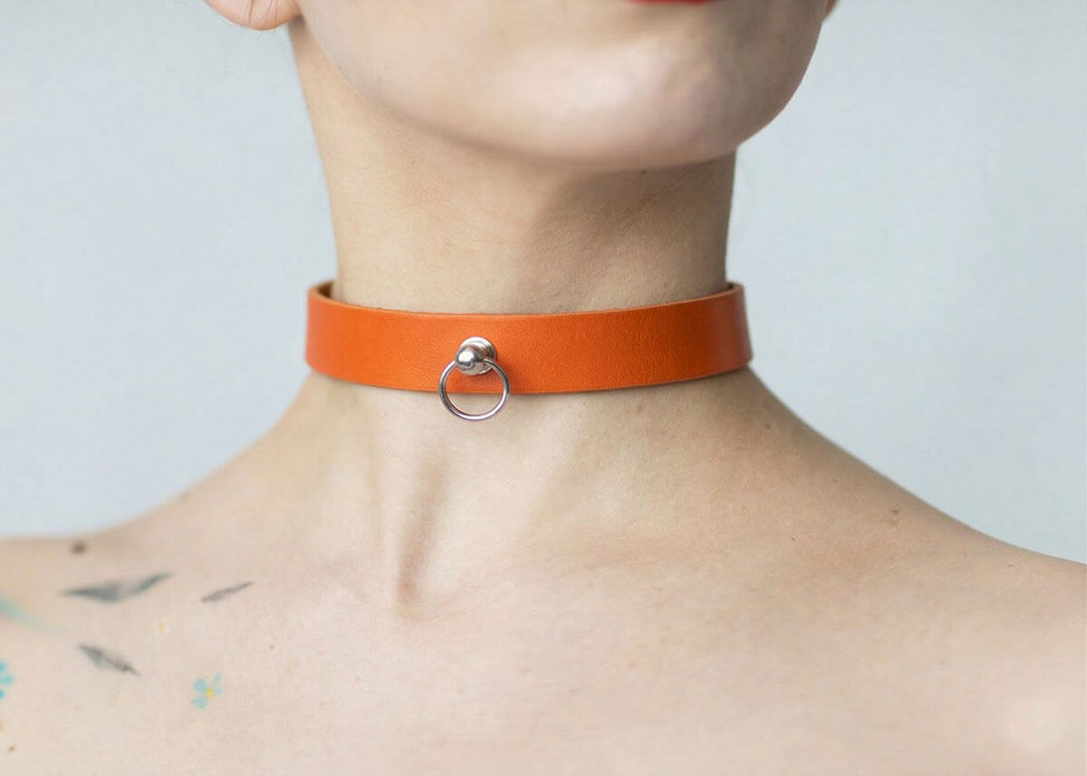 Kožený Choker C004 v oranžovej farbe s unikátnym krúžkom na stopke prináša energiu a odvážny výraz, ktorý rozbije stereotyp. Živý detail, ktorý si pýta pozornosť.