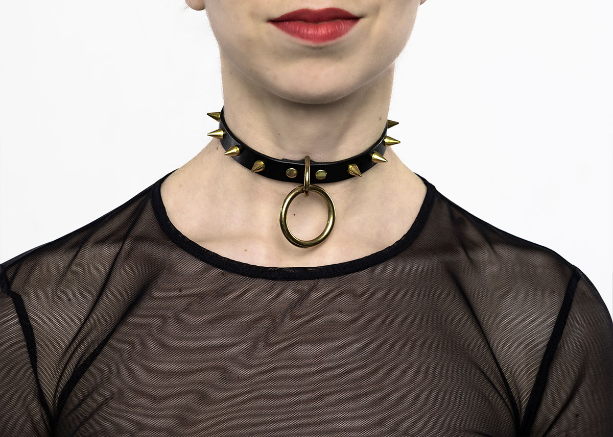 Štýlový kožený Choker C007 so zlatými hrotmi a voľne visiacim O-krúžkom v čiernej farbe kože - nechajte sa dobýjať a ukážte svoju vnútornú silu.